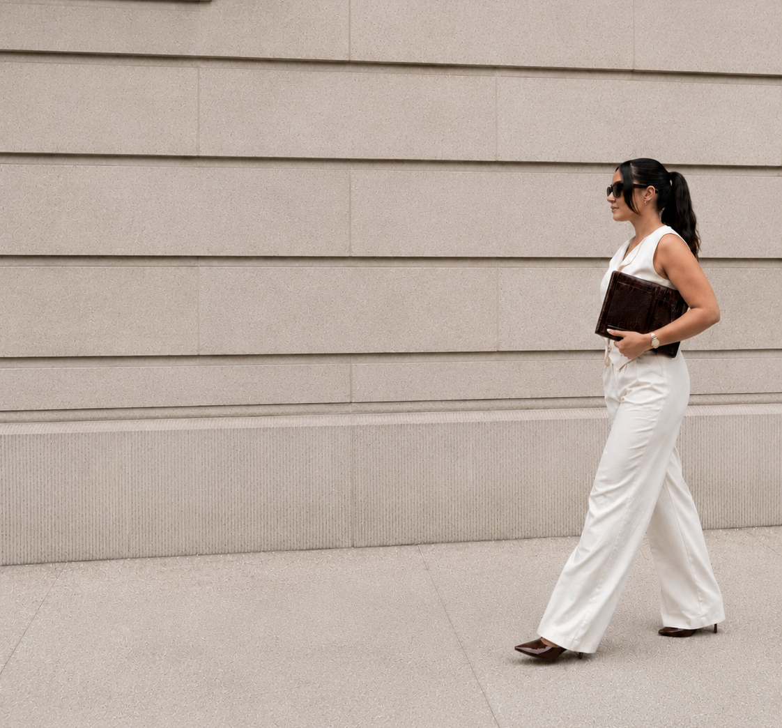 Woman walking against a beige wall holding Wesbury Collection MacBook case
